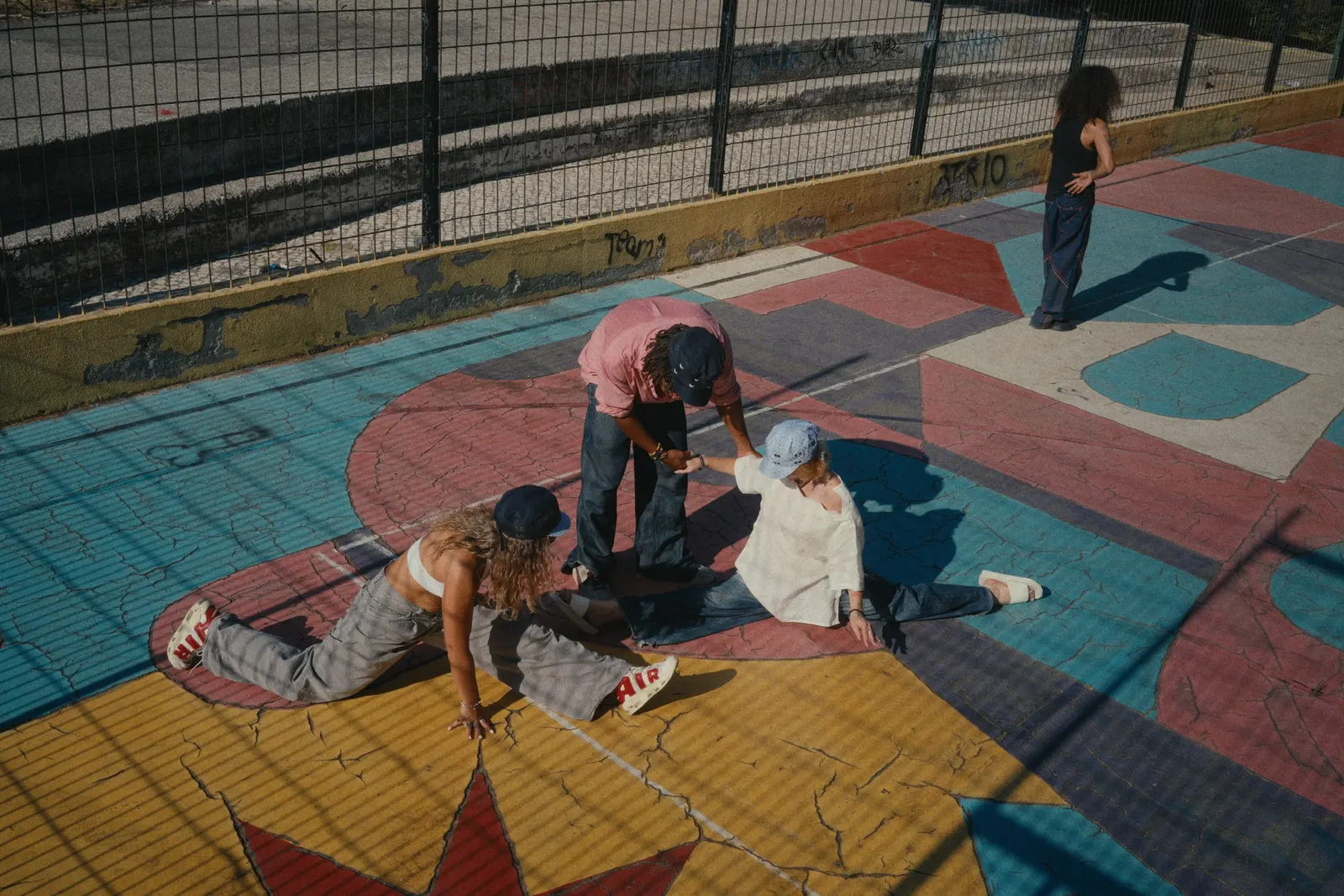 Three people on a painted basketball court in Lisbon, seen from above