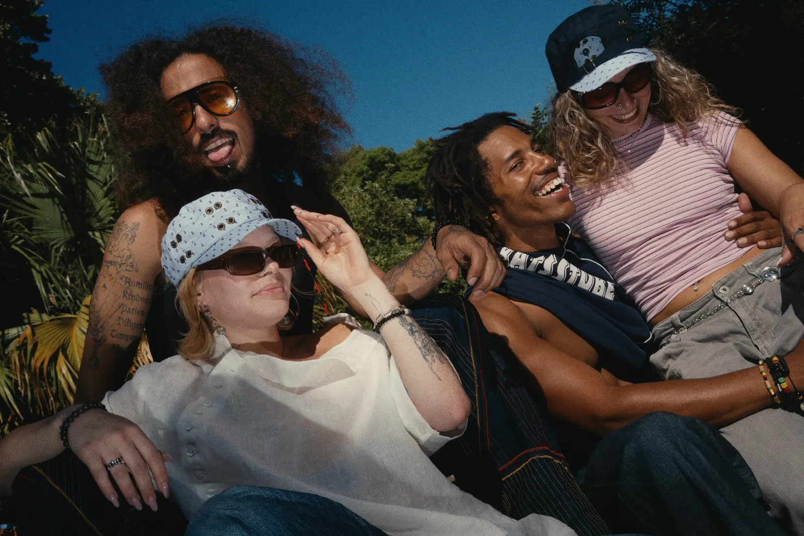Three people wearing the caps in a Lisbon park under a blue sky
